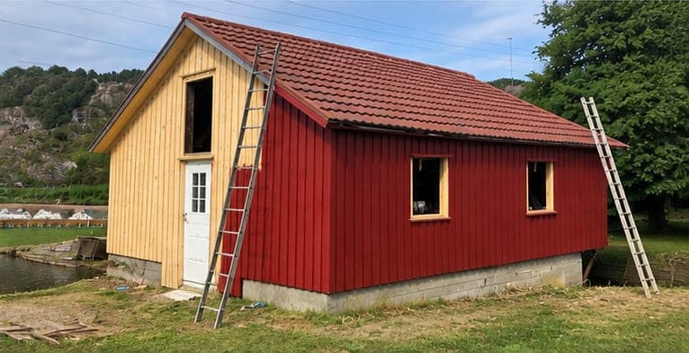 Naustet ferdig malt, med stiger satt opp langs veggen